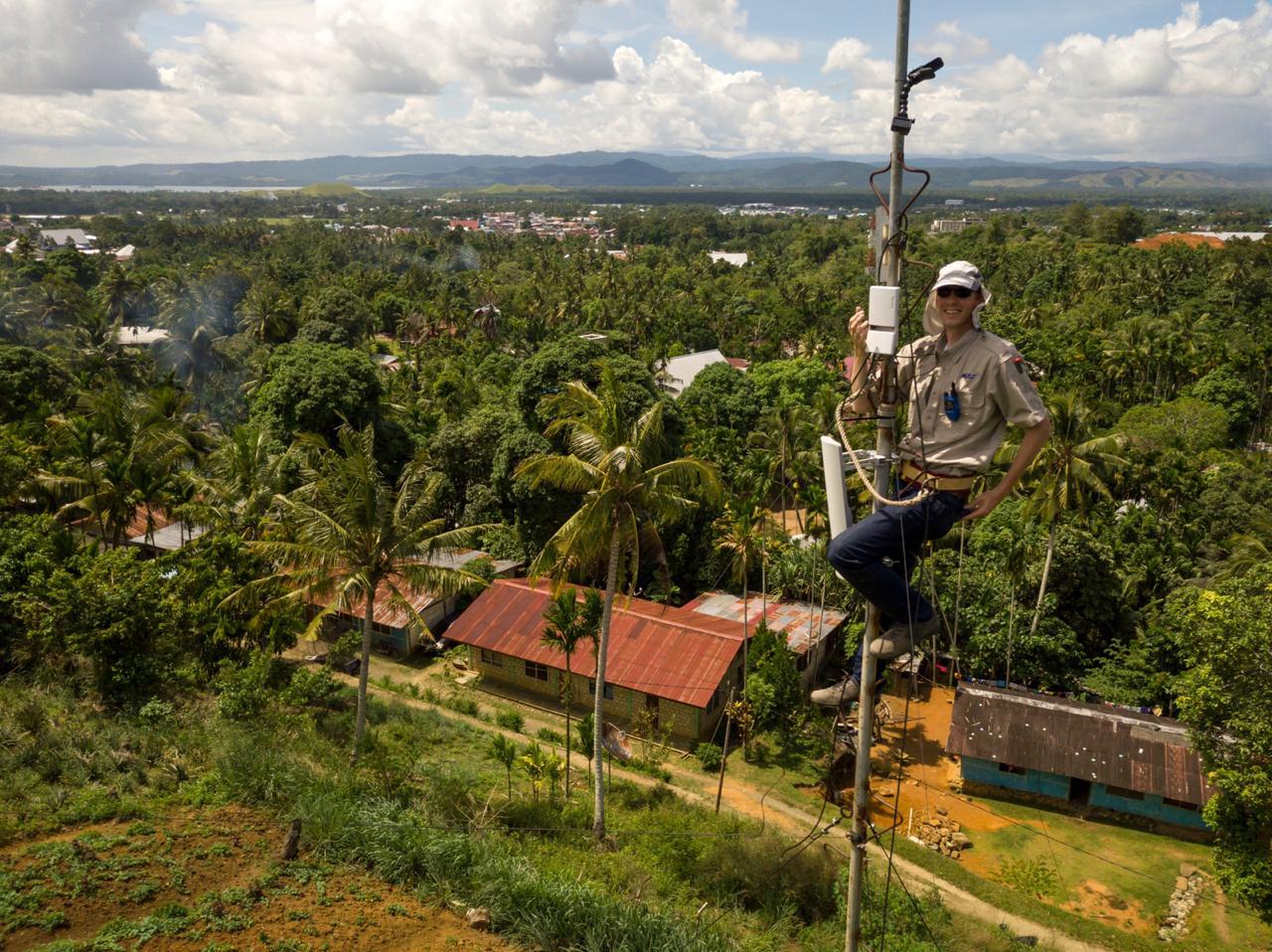 Wilbert Rietveld on an antenna mast above a tropical landscape